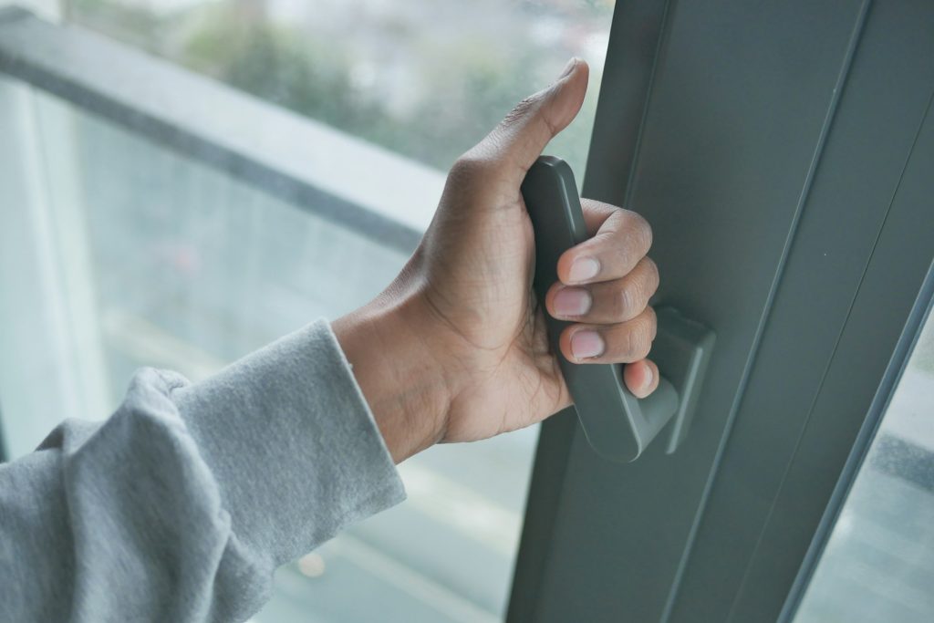 hand open gray plastic pvc window at home at early morning