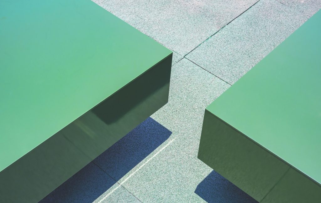 Part of 2 green rectangle benches made from aluminum composite tiles on artificial grass mat floor