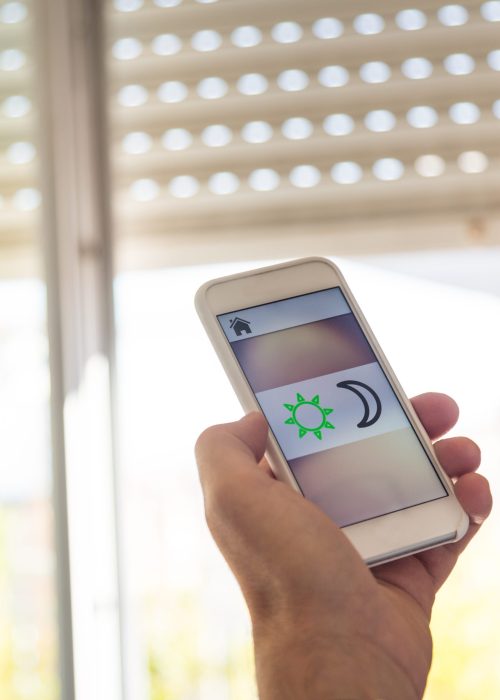 Smart home: man controlling blinds with app on his phone